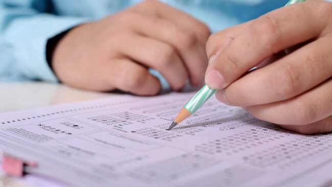 An overwhelmed person surrounded by papers and notes on a desk. — cheap PDF strategy