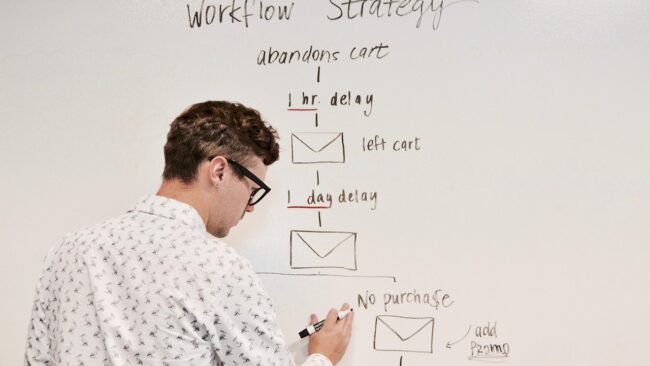 Person composing an email on a laptop with marketing materials